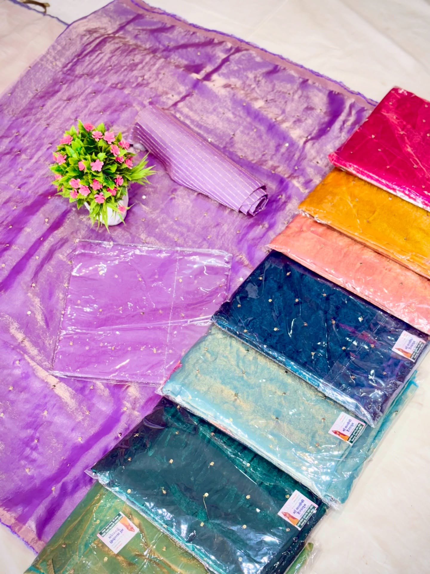 A vibrant collection of multicolor traditional Indian dress materials and saree sets featuring rich fabrics, festive designs, and assorted patterns.